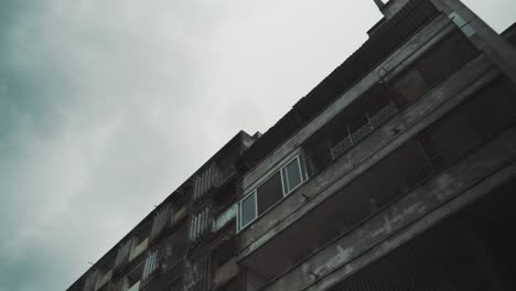 slow panning shot of a creepy rundown apartment block in the heart of maputo, mozambique.