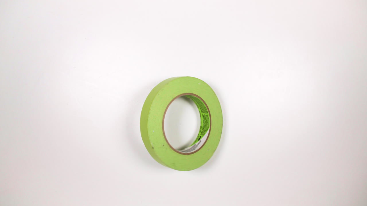 흰색 탁상에서 회전하는 녹색 접착 테이프
