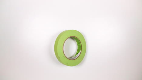 Green-Adhesive-Tape-Spinning-On-White-Tabletop