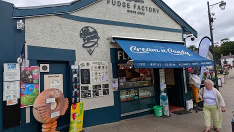 people walking past a fudge shop in llangollen