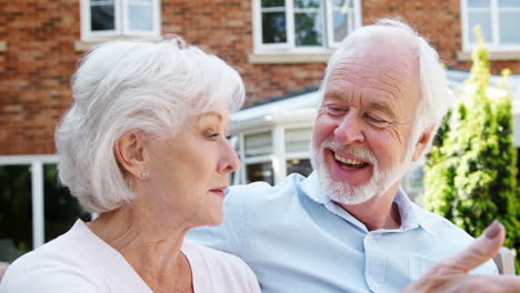 Retired-Couple-Sitting-On-Bench-And-Talking-In-Assisted-Living-Facility