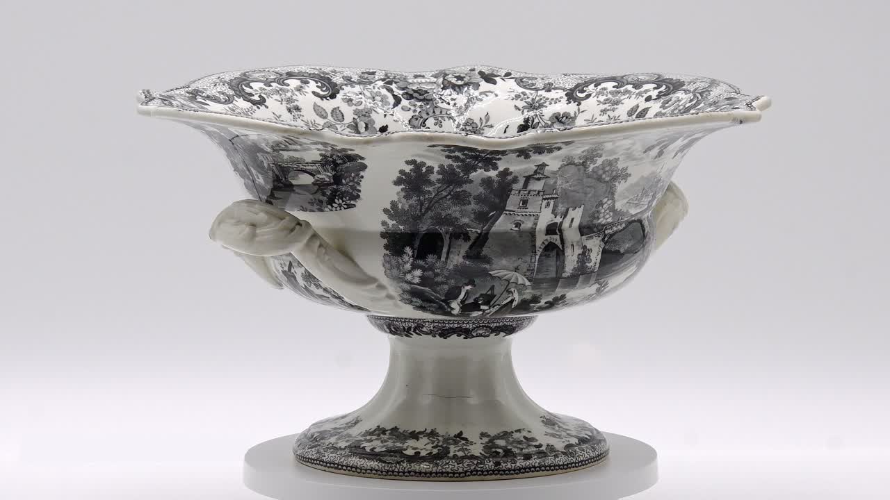 This decorative antique bowl features detailed patterns and elegant handles, highlighting exceptional craftsmanship.