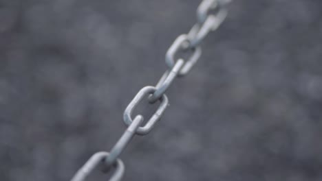 isolated strong metal chain sways in breeze