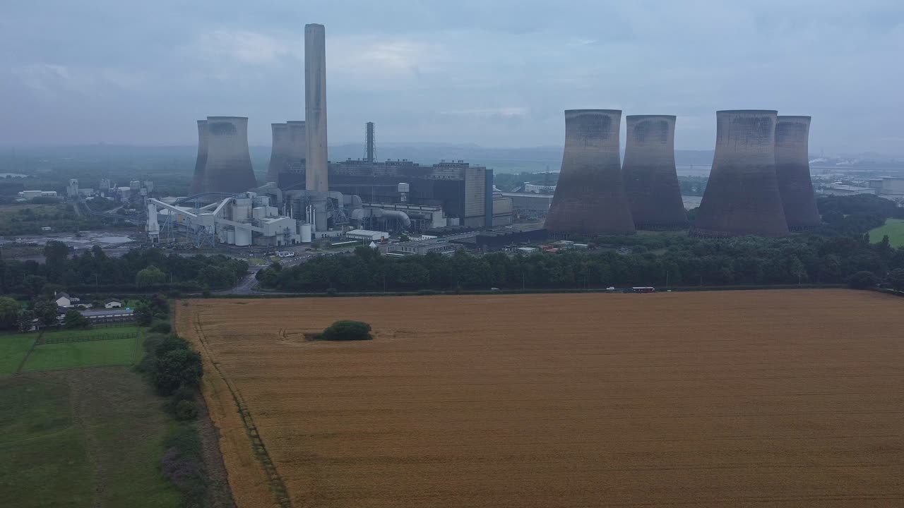 imponente torre de refrigeración de hormigón central eléctrica tierras de cultivo campo vista aérea lento derecha dolly