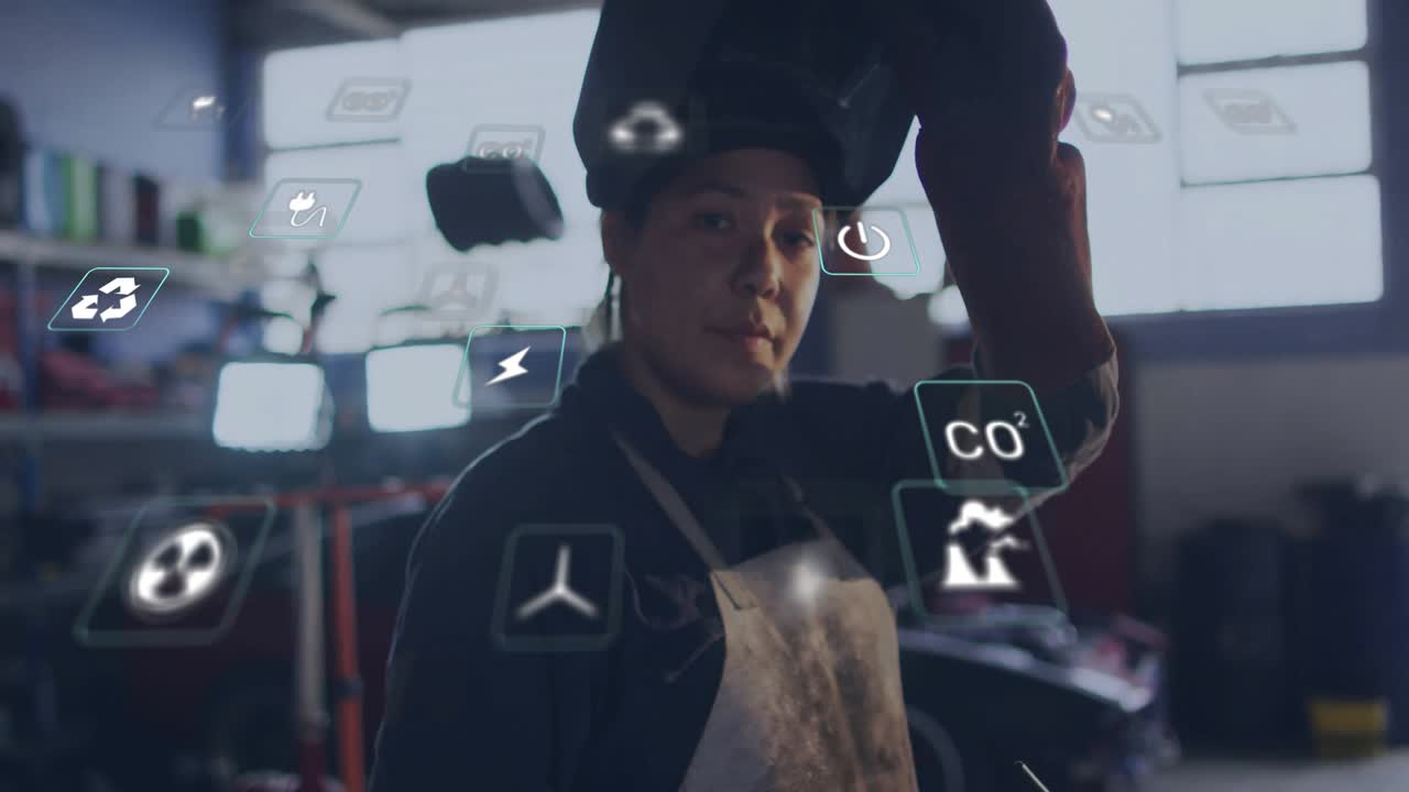 Welder lifting hand to helmet flipping visor as digital icons shifting around her for factory data