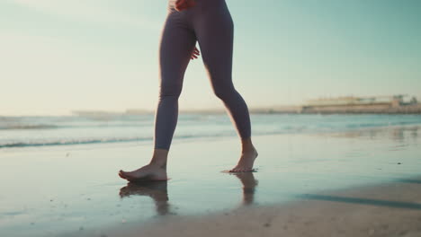 Close-up-female-legs-on-the-beach.