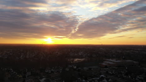 An-drone-view-of-a-Long-Island-neighborhood-during-a-golden-sunrise-with-clouds-and-blue-skies
