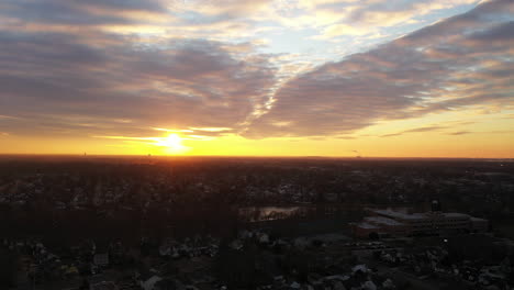 Una-Vista-De-Drones-De-Un-Barrio-De-Long-Island-Durante-Un-Amanecer-Dorado-Con-Nubes-Y-Cielos-Azules