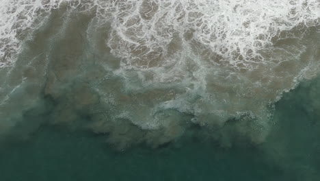 Wellenbewegung-In-Ufernähe-Wirbelt-Sandwolken-Im-Meerwasser-Auf,-Abstrakt