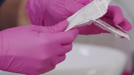 abrir una jeringa para preparar una inyección de botox - cierre aislado de las manos y la aguja de la doctora
