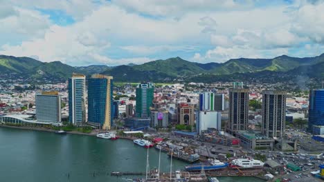 Hyperlapse-aerial-view-of-the-vibrant-Caribbean-city-of-Port-of-Spain,-Trinidad-and-Tobago-with-an-amazing-cloudscape-in-the-background