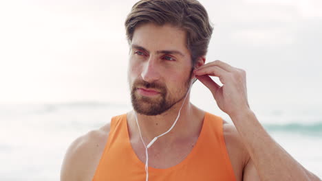 man listening to fitness music on the beach