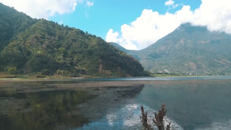 Drohnenantenne,-Die-Vom-Ufer-In-Richtung-Der-Berge-Des-Wunderschönen-Atitlan-sees,-Guatemala,-Fliegt