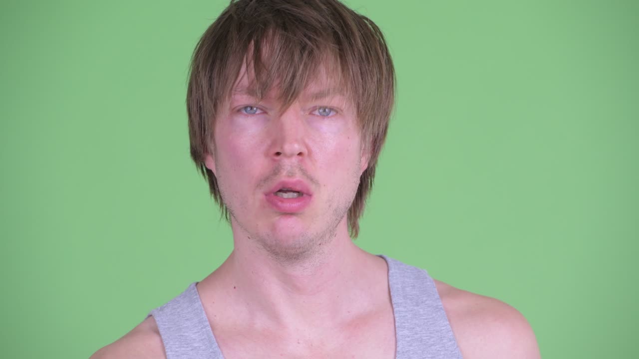 초록색 스튜디오 배경에 우울한 모습을 보이는 백인 남자의 초상화