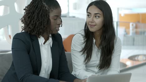 smiling young businesswomen using laptop