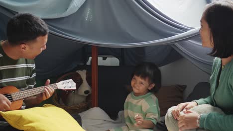 happy asian family singing and dancing in a diy tent at home