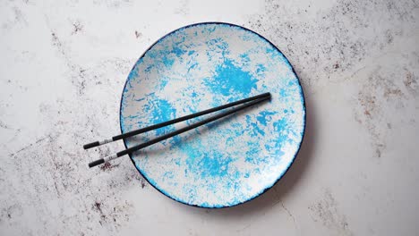 Blue-hand-painted-ceramic-serving-plate-with-wooden-chopsticks-on-side