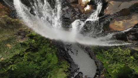 Looking-down-over-a-waterfall-as-water-cascade-down-to-a-natural-swimming-pool-below