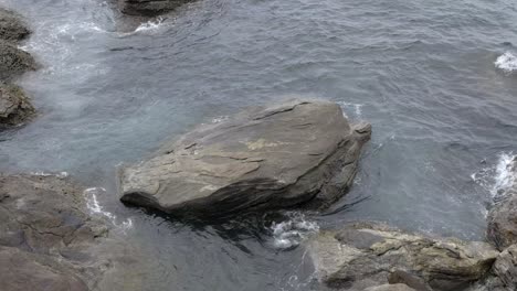 Aguas-Oceánicas-Que-Fluyen-Sobre-Grandes-Rocas-En-La-Costa-Costera