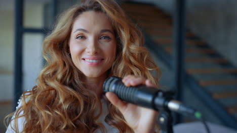 Woman-with-microphone-looking-at-camera.-Joyful-lady-holding-microphone