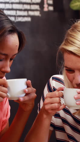 amigos bebiendo café y mirando el teléfono inteligente