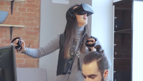 the beautiful girl playing games with virtual reality goggles at the office