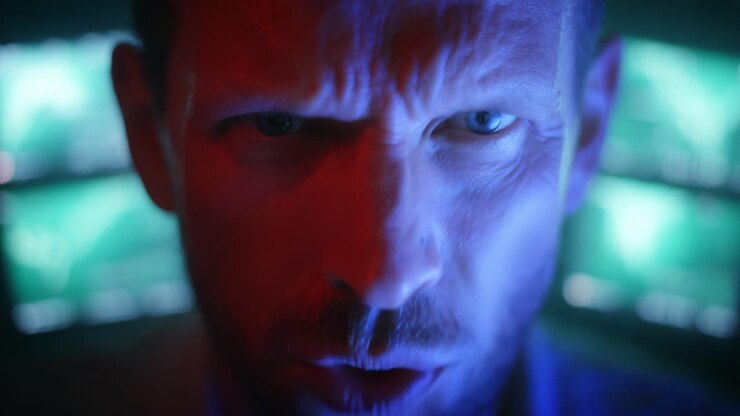 Intense Close-Up of a Man's Expression in a Dark Environment with Glowing Screens, Capturing a Moment of Anger and Emotion in a Dramatic Setting