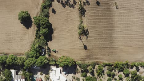 top view of the farm land in todos santos, a person with a tractor on the farmland for agriculture help on a sunny day in mexico