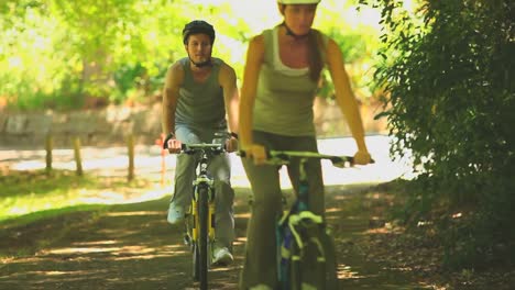 Pareja-Deportiva-En-Bicicleta-Por-Un-Sendero