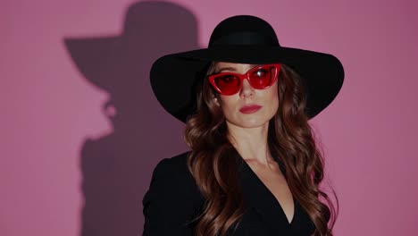 stylish woman in black hat and red sunglasses