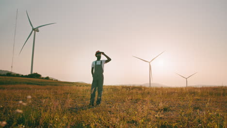 wind turbine worker in a field at sunset