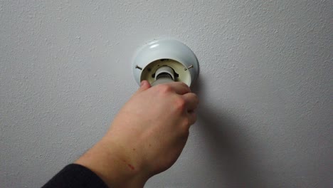 quitando una cubierta de luz a una luz rota y quemada y se rompe aún más dejando la pieza de tornillo en el zócalo