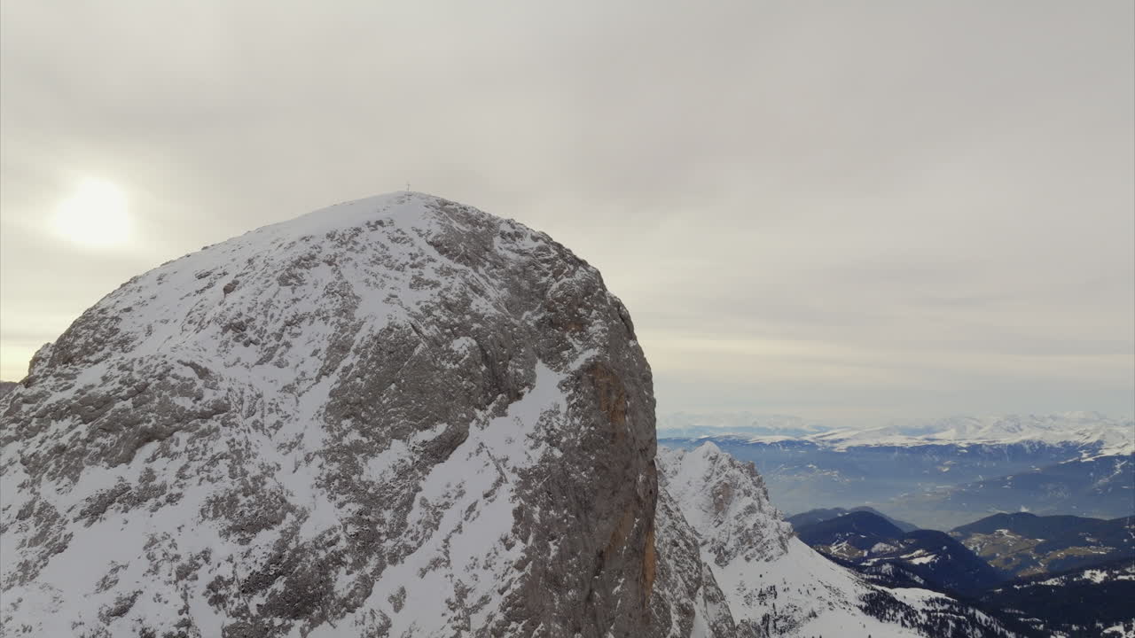 disparo aéreo de la cima de la montaña cubierta de nieve de grande sass de putia con un paisaje épico visto en el fondo