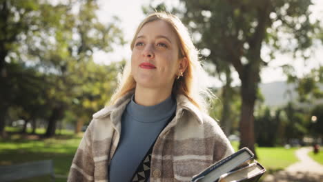 woman holding books in park