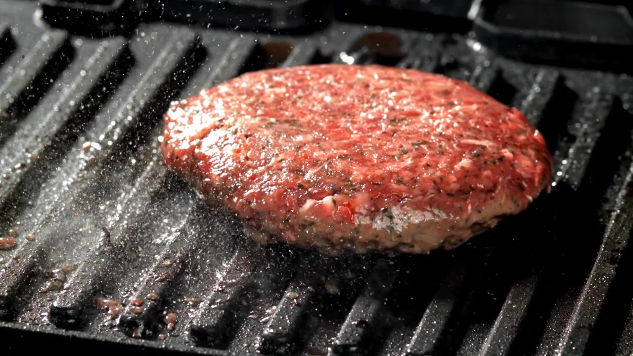 Raw Burger Patty Sizzling on Hot Grill in Slow Motion
