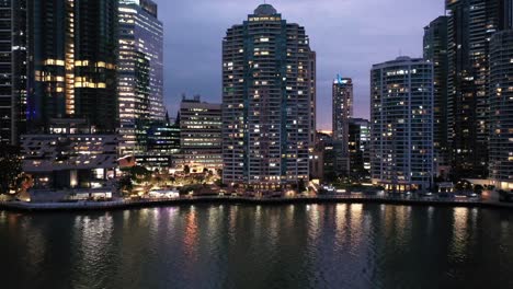 drone shot of eagle st pier city reach boardwalk, camera slowly ascending revealing stunning red sunset behind brisbane's skyscrapers