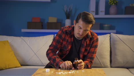 el hombre que toma las pastillas en la mesa con las manos temblando. suicidio.