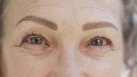 portrait close up of eyes of happy senior caucasian woman looking at camera smiling, slow motion