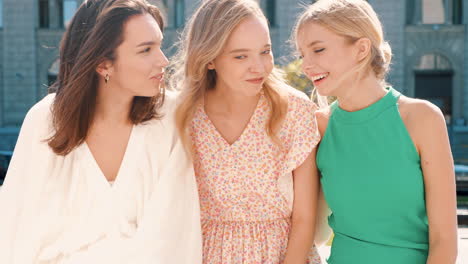 three young women laughing and enjoying each other's company outdoors