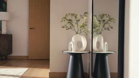 panning shot of a small side table with a plant a modern vase and a modern piece of art