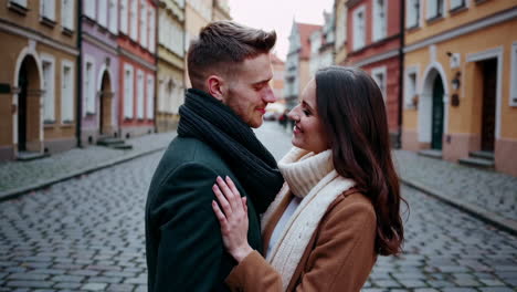 a romantic couple embracing on a cobblestone street in an old city