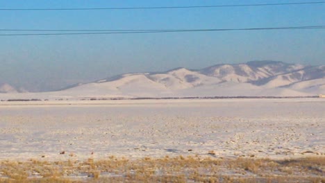 remote mongolian landscape during winter. pov shot from moving train