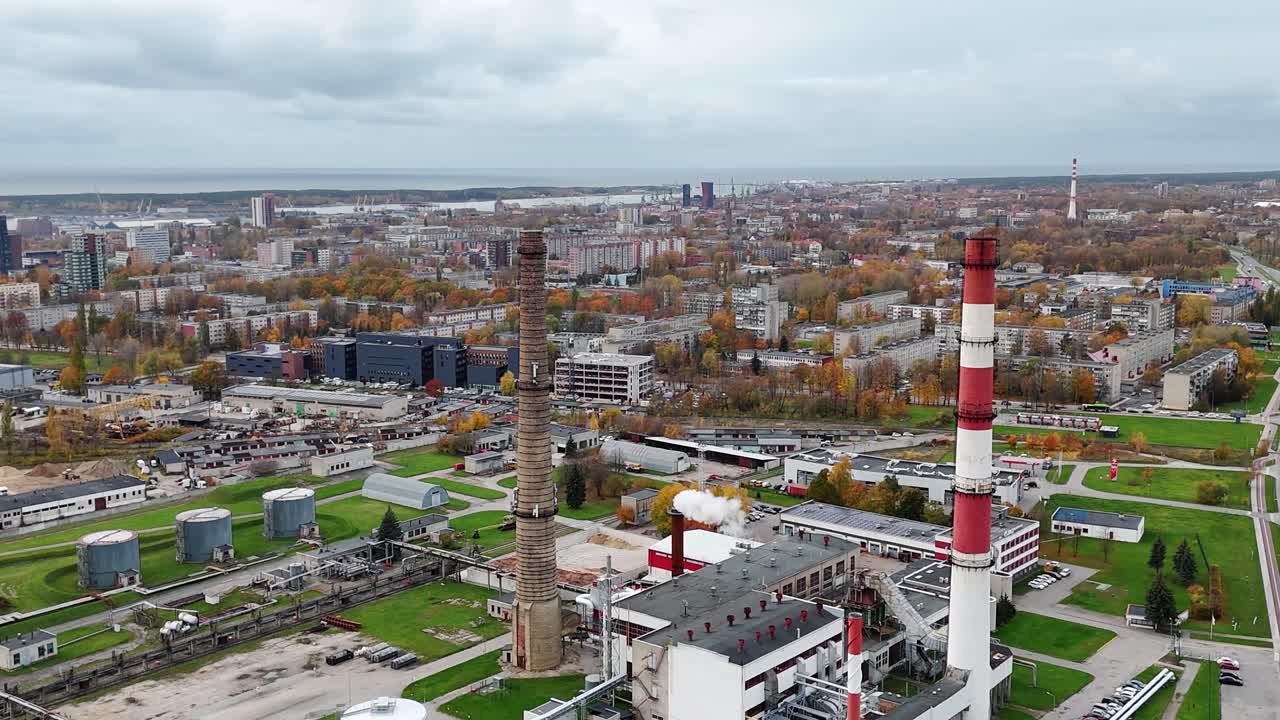 Aerial view of Klaipeda industrial chimneys and city skyline with a cloudy autumn backdrop