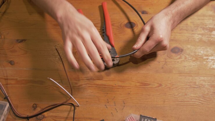 Stripping Positive and Negative electrical wires with Wire Strippers