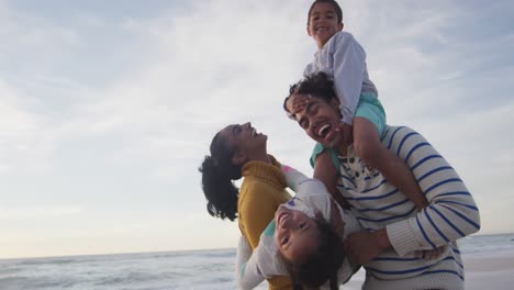 Glückliche-Hispanische-Familie,-Die-Sich-Bei-Sonnenuntergang-Am-Strand-Amüsiert