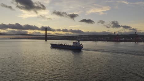 Drone-footage-of-tanker-ship-heading-under-the-bridge-in-Lisbon