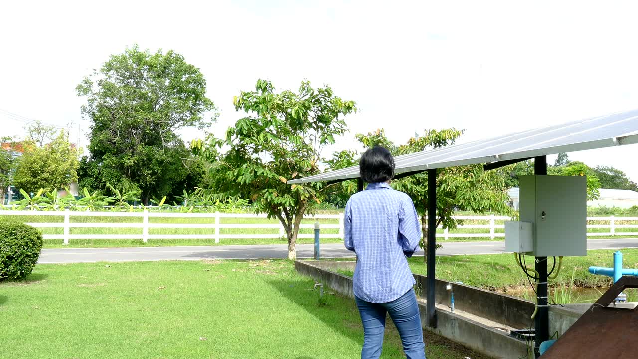 농업 전문가는 농장에서 물을 핑하기 위해 태양 전지를 모니터링하기 위해 태블릿을 사용합니다. 모바일 앱 기술을 사용하여 농업에서 전력 관리를합니다.