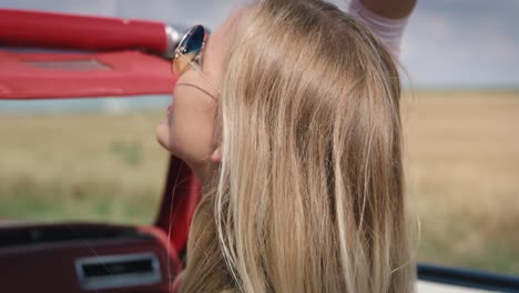 close up of happy blonde woman going on a trip by car