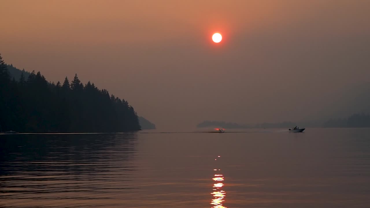 보트와 수상 스키어와 함께 bc에서 일몰을 감상