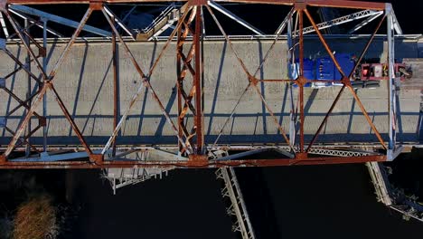 birds-eye-view of an old bridge, a semi-truck passes by.